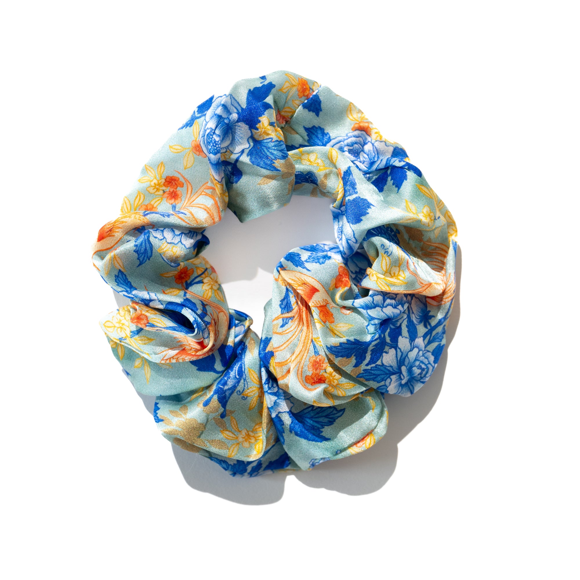 Singlapa silk scrunchie with a multicolored floral pattern featuring birds and butterflies, displayed on a white background.