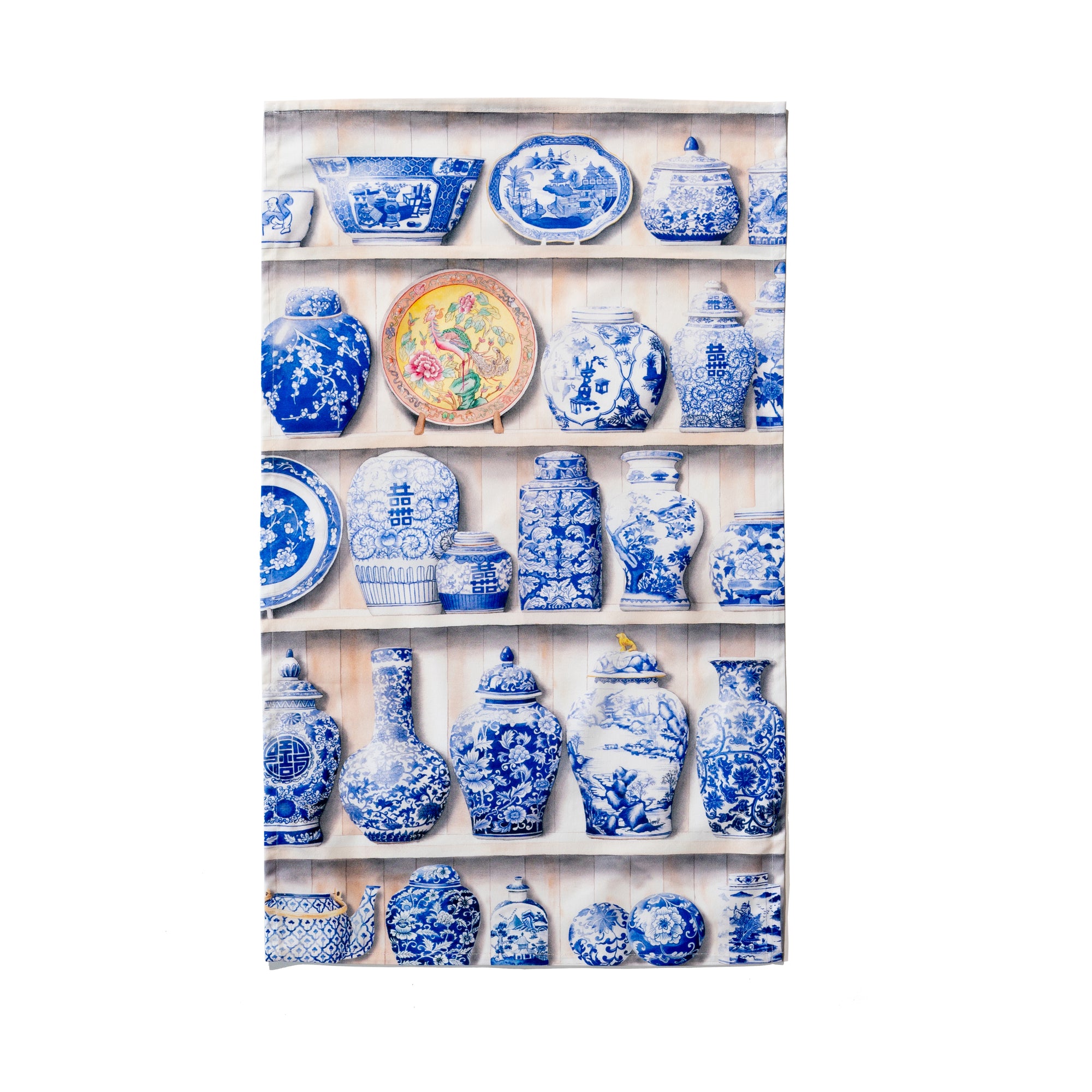 Singlapa tea towel featuring a variety of traditional Chinese porcelain arranged on shelves, with a detailed Peranakan porcelain plate.