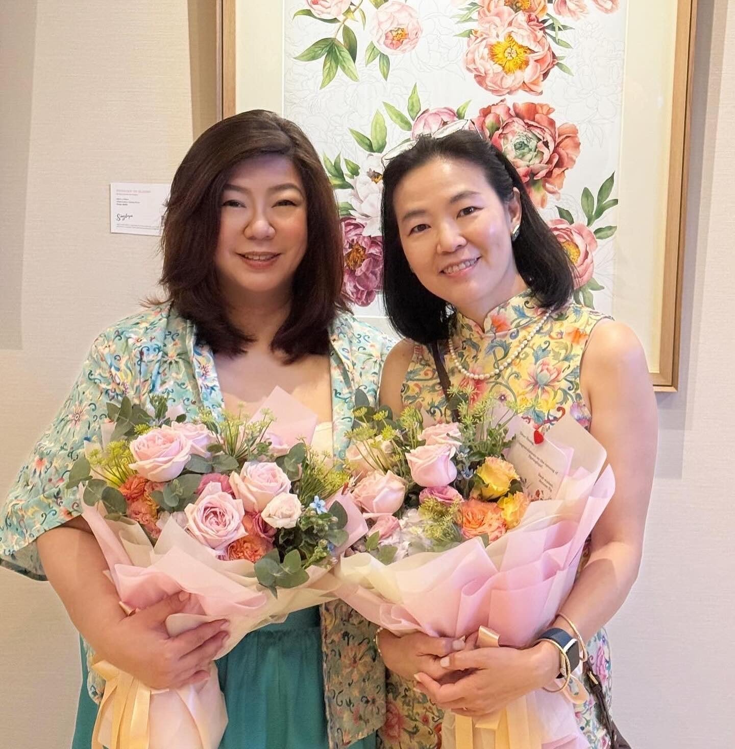 Founders of Singlapa dressed in signature prints, holding bouquets and celebrating the brand’s journey