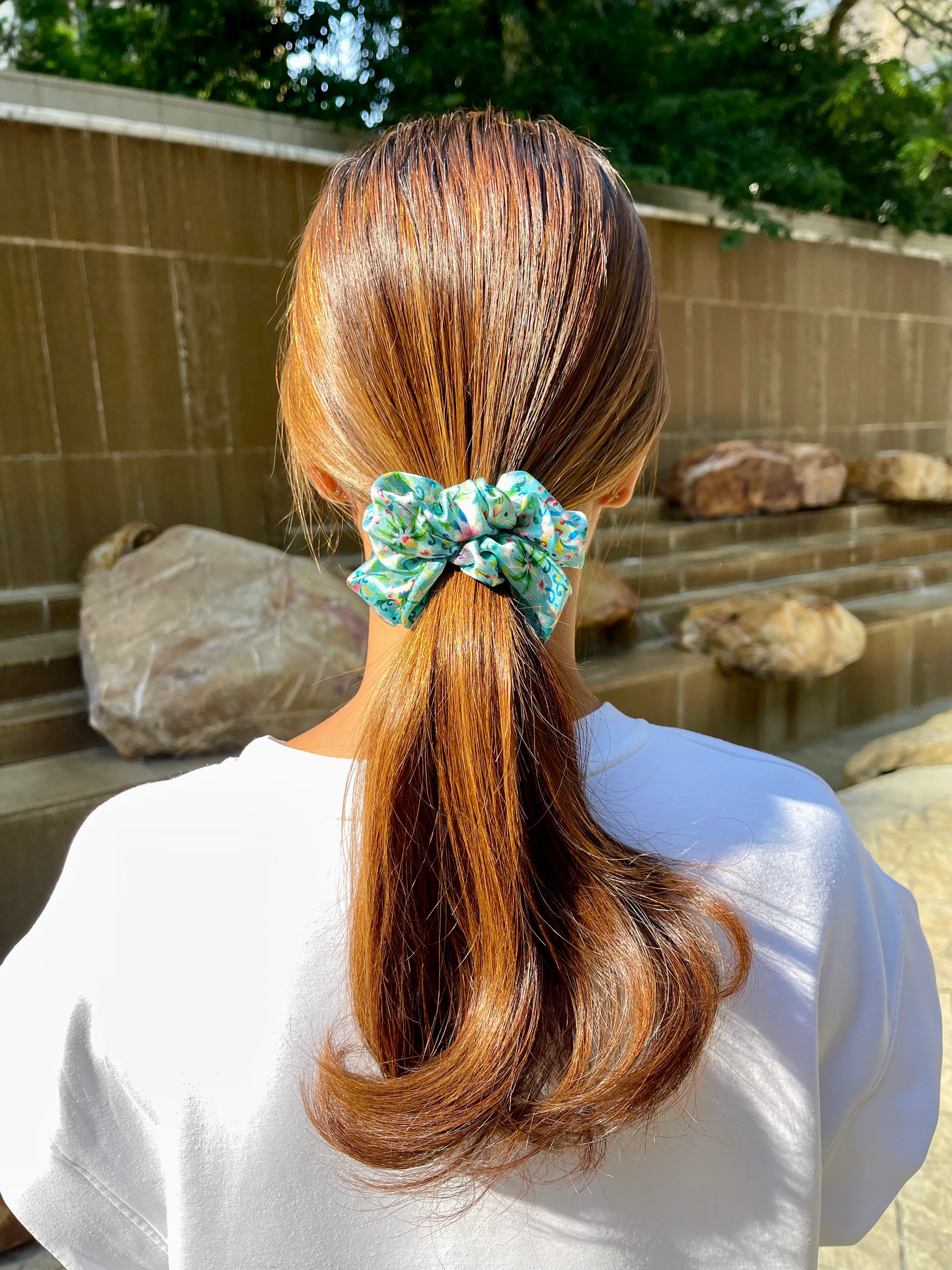 Woman wearing blue colourful floral silk scrunchie
