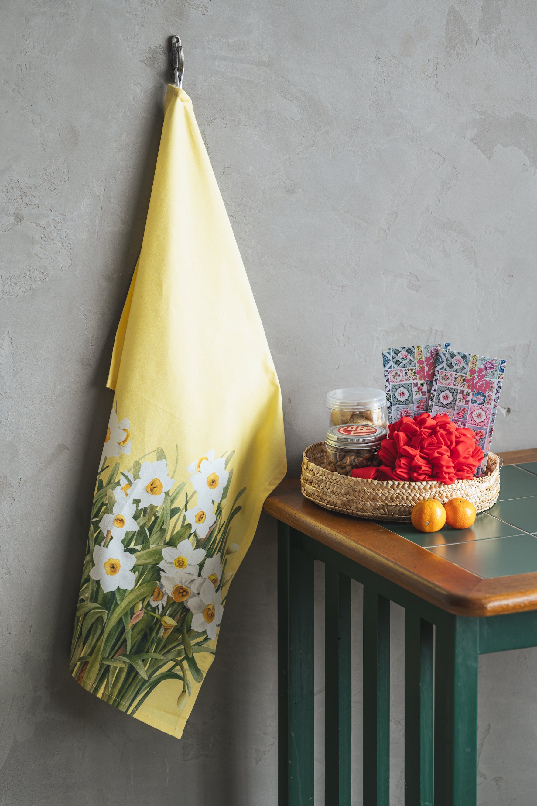 Lifestyle picture of narcissus tea towel beside a table with snacks and oranges