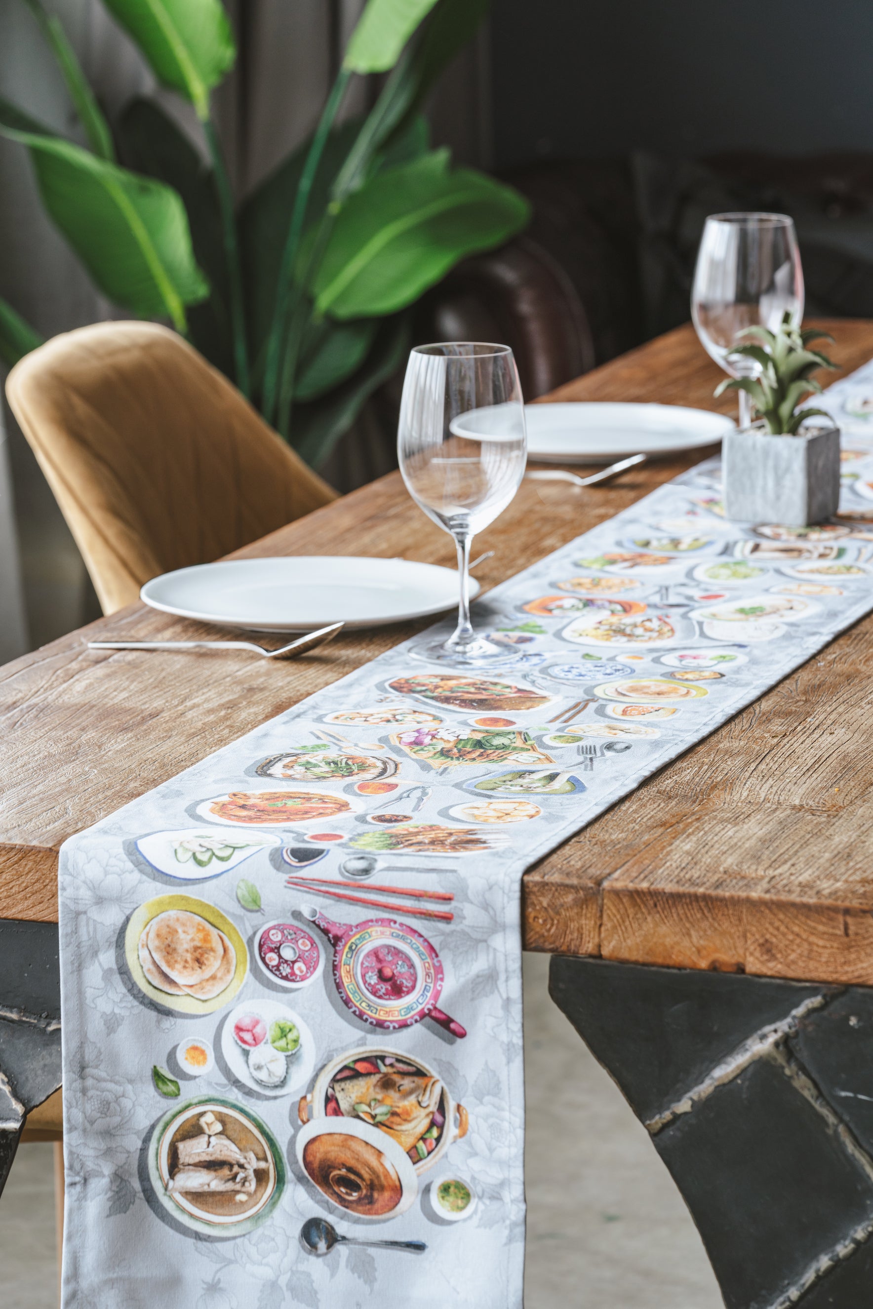 Lifestyle image of table runner on a dining table with wine glasses and tableware.