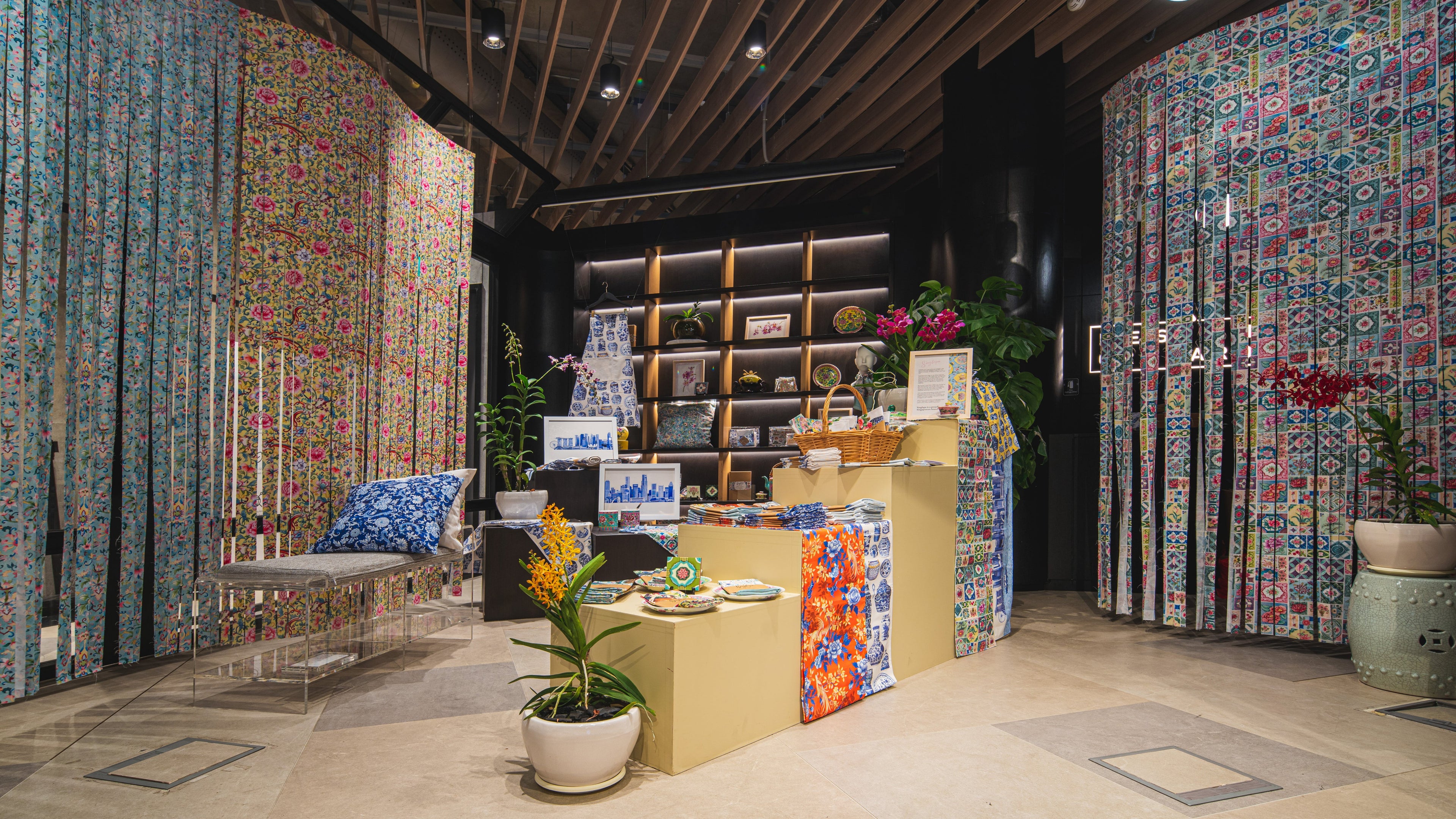 Decorative fabric display with patterned curtains and shelves featuring Singlapa homeware collection