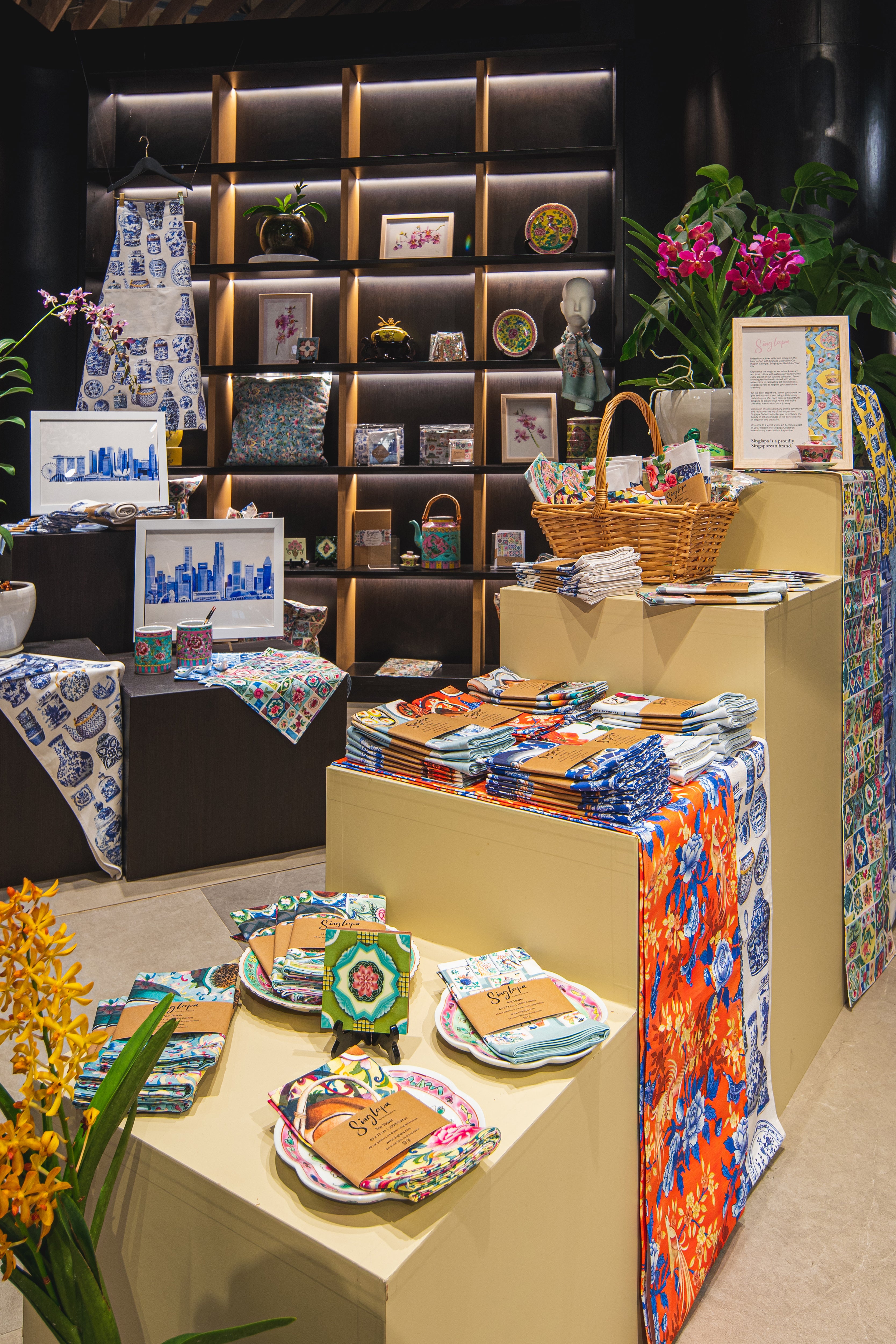Singlapa homeware display featuring aprons and tea towels neatly arranged on decorative shelves