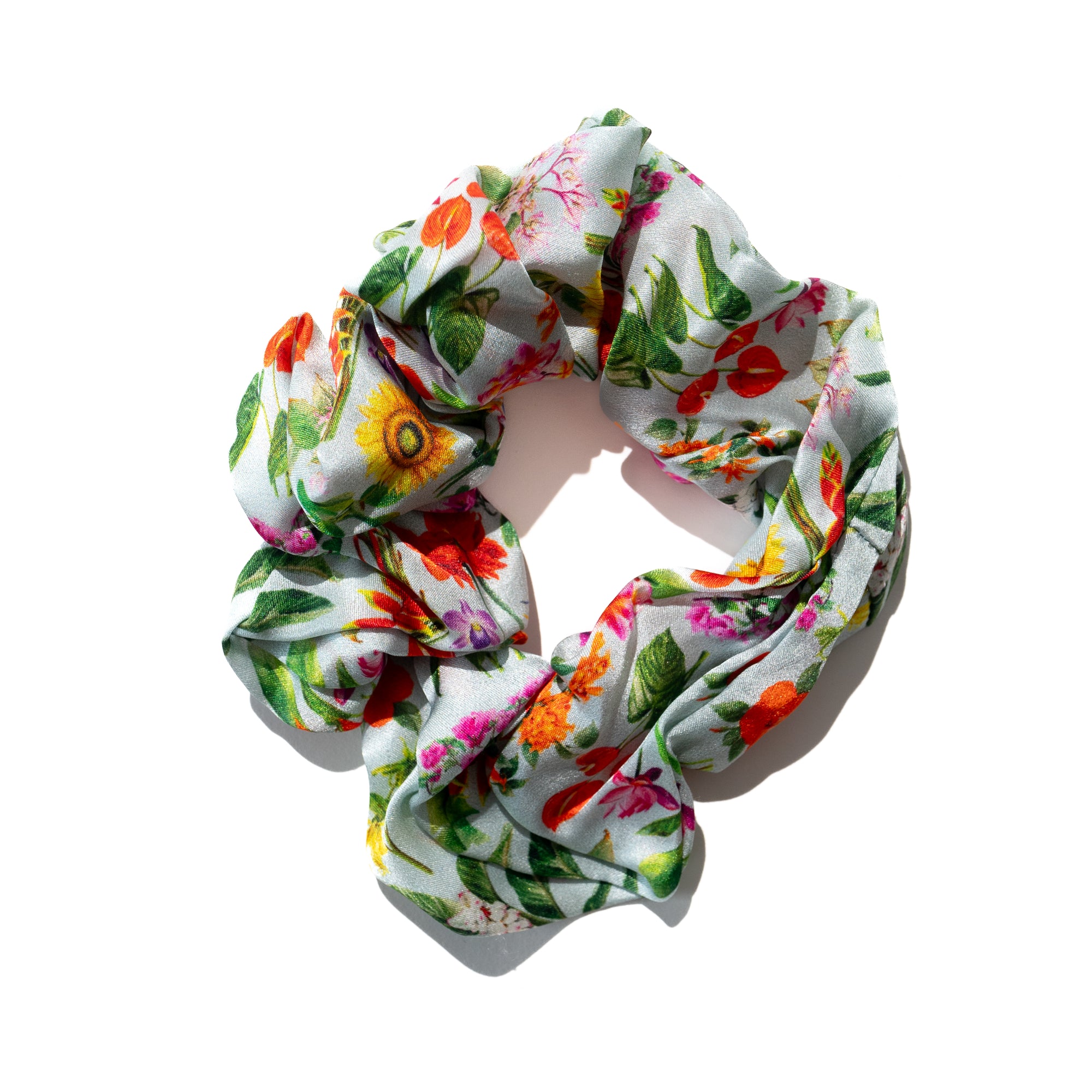 Singlapa silk scrunchie with a vibrant tropical flower print, displayed on a white background.
