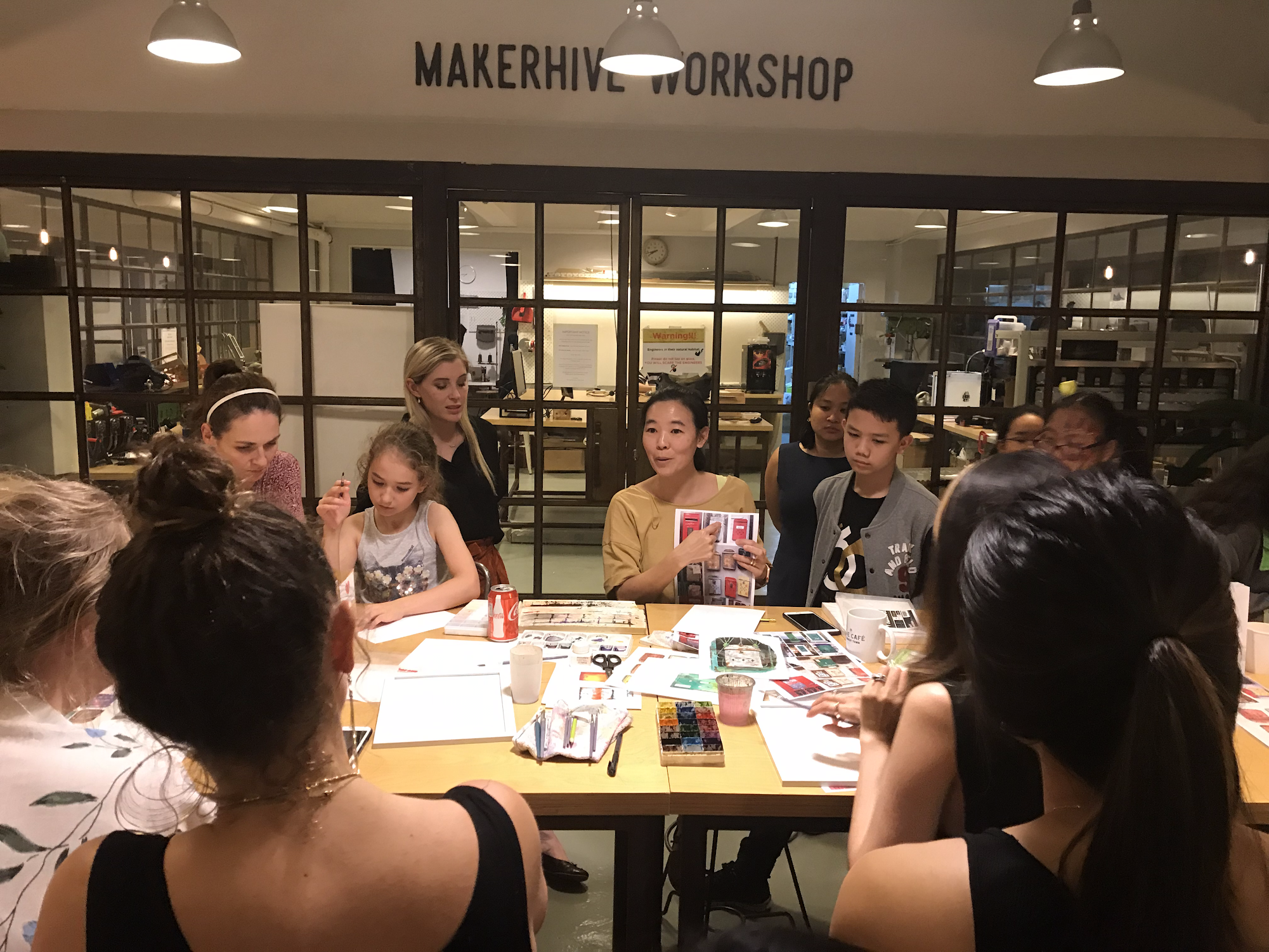 Instructor demonstrating watercolor techniques to people in a creative art workshop