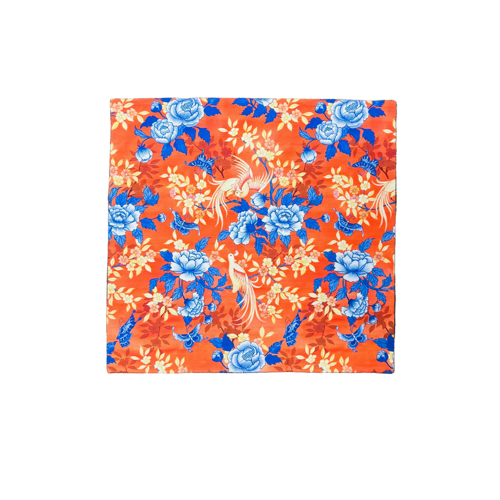 Floral patterned cushion cover with bird and butterfly designs on a white background.