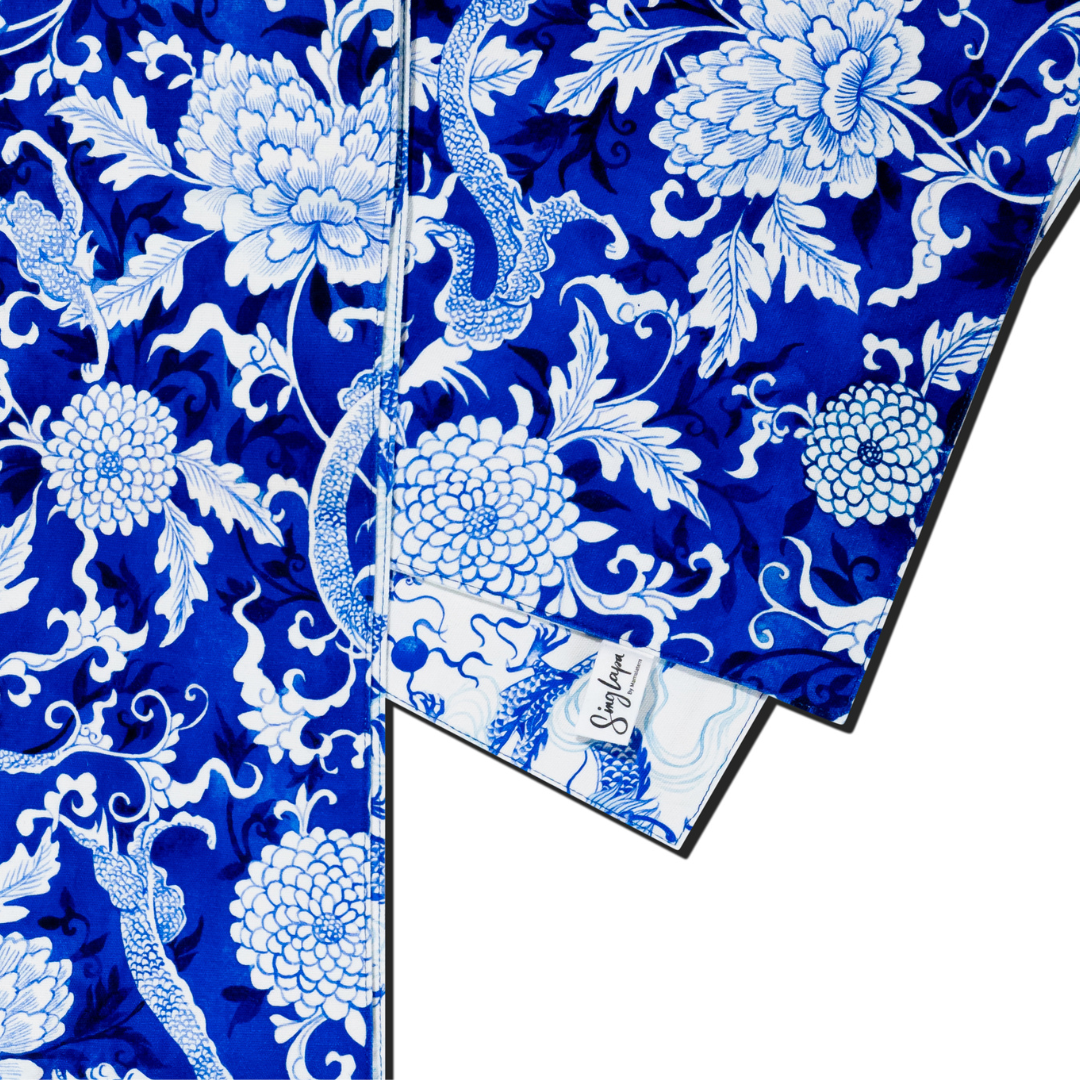 Blue and white dragon and floral patterned table runner with a visible brand label.