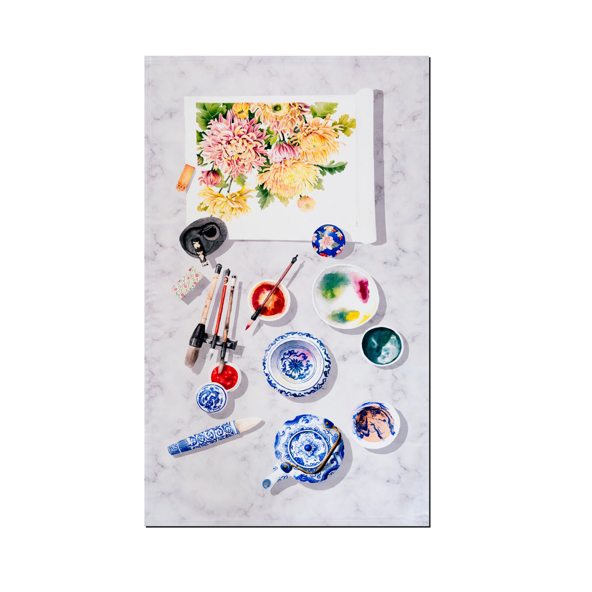 Singlapa tea towel with watercolor painting, brushes, and paint containers on a marble surface.