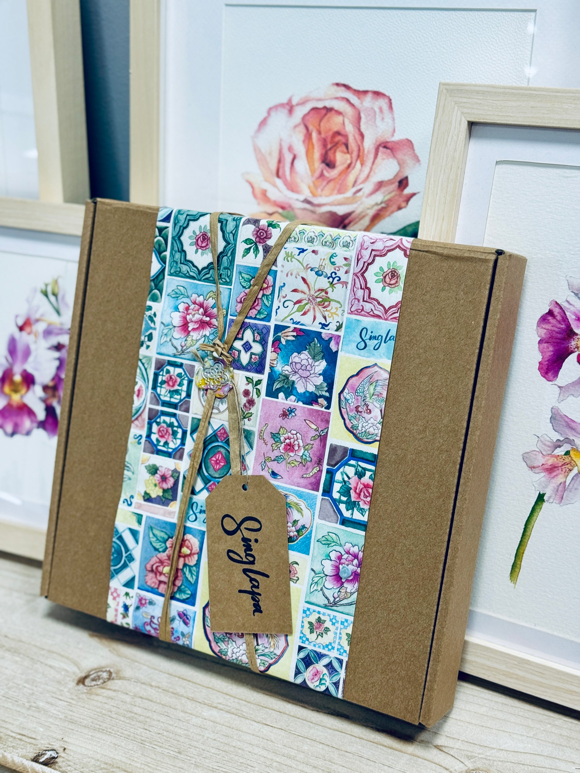 Floral-patterned box with a tag on a wooden surface