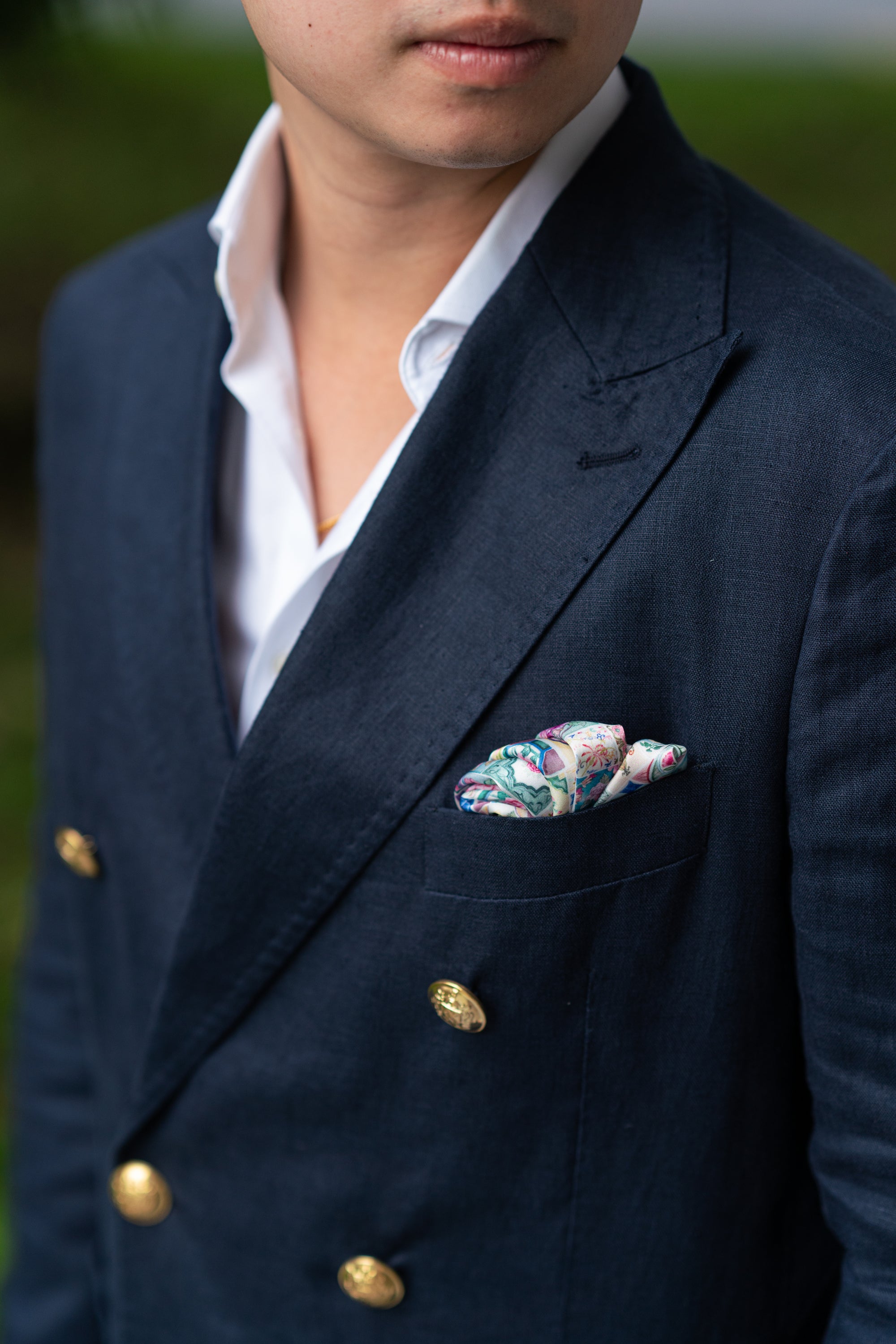 Man wearing a navy suit with a colourful pocket square.