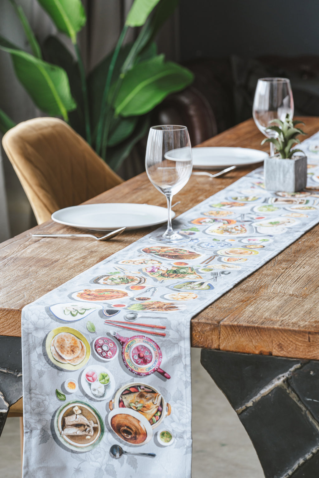 Lifestyle image of table runner on a dining table with wine glasses and tableware.