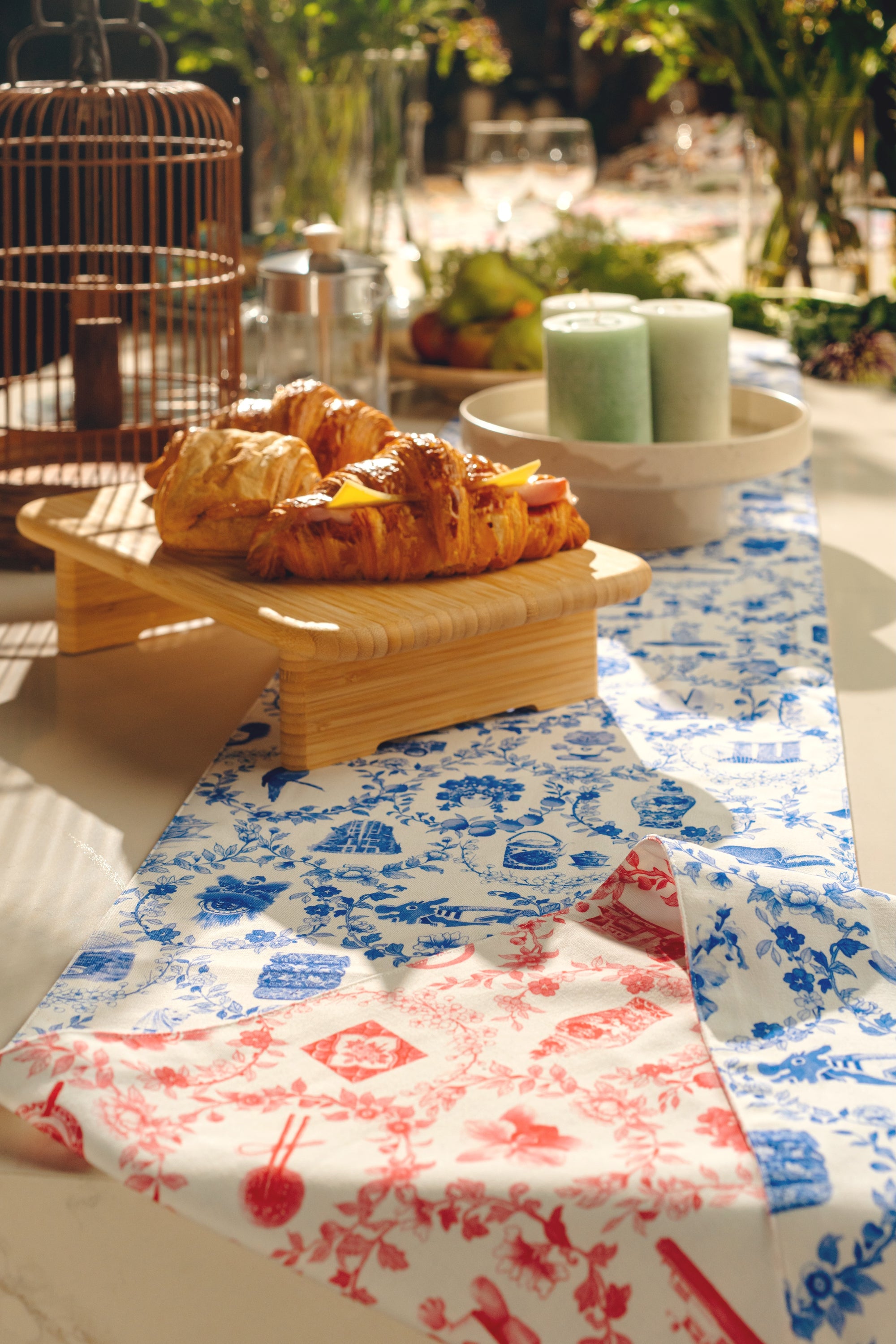 Pastries on a wooden tray with a floral and singapore icon tablecloth in an outdoor setting