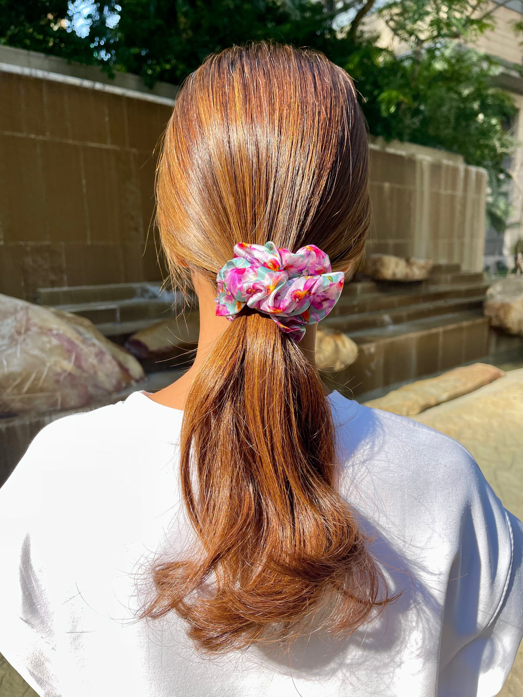 Woman wearing a grey and purple silk scrunchie with orchids and birds design 