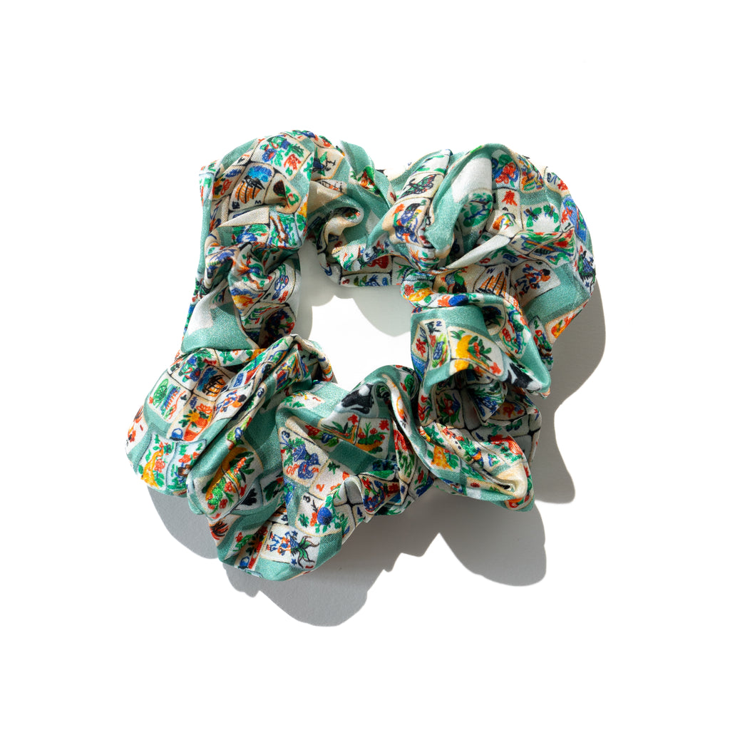 Singlapa silk scrunchie with a multicolored geometric mahjong pattern, displayed on a white background.