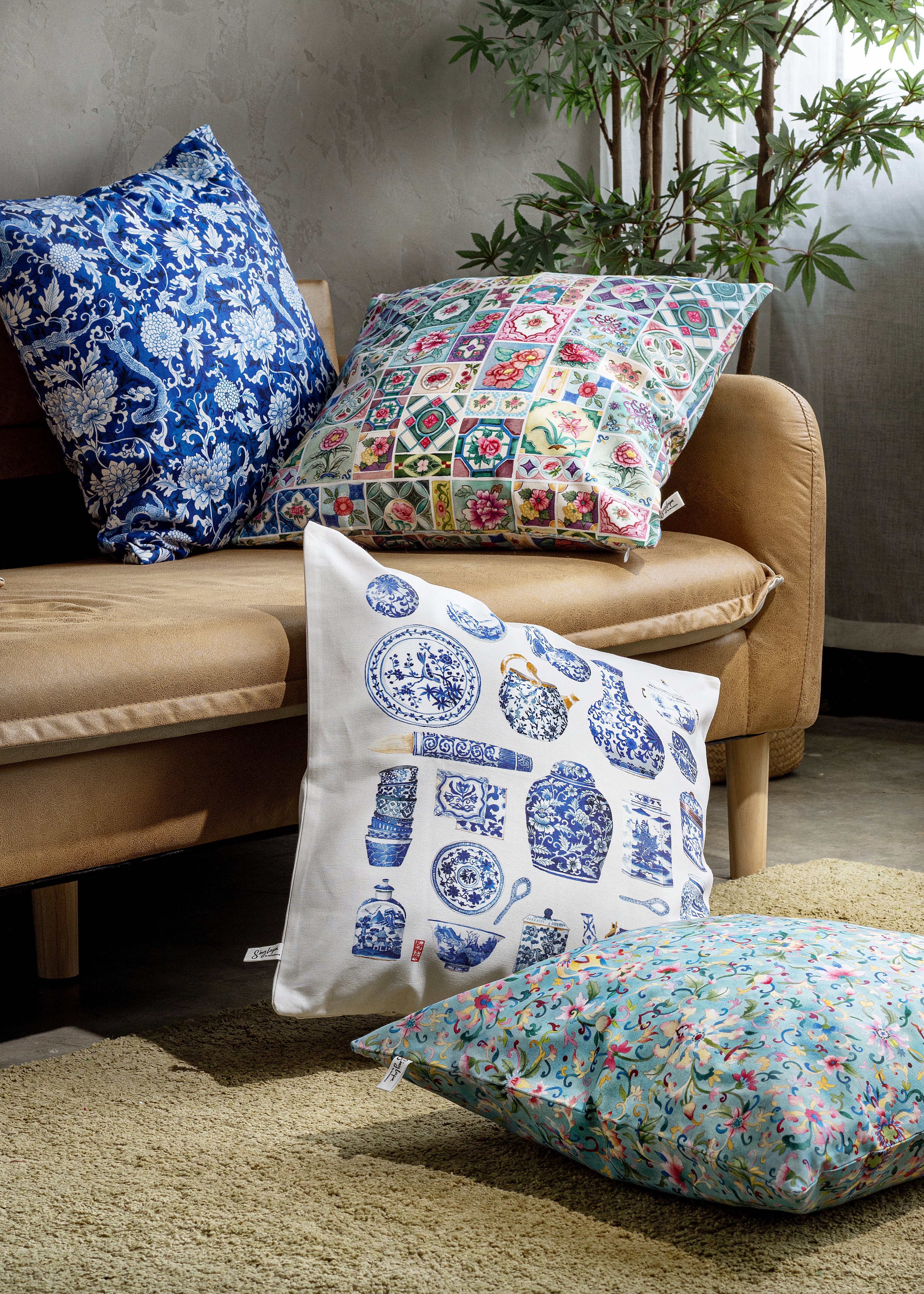 Decorative pillows with floral and patterned designs on a beige sofa.