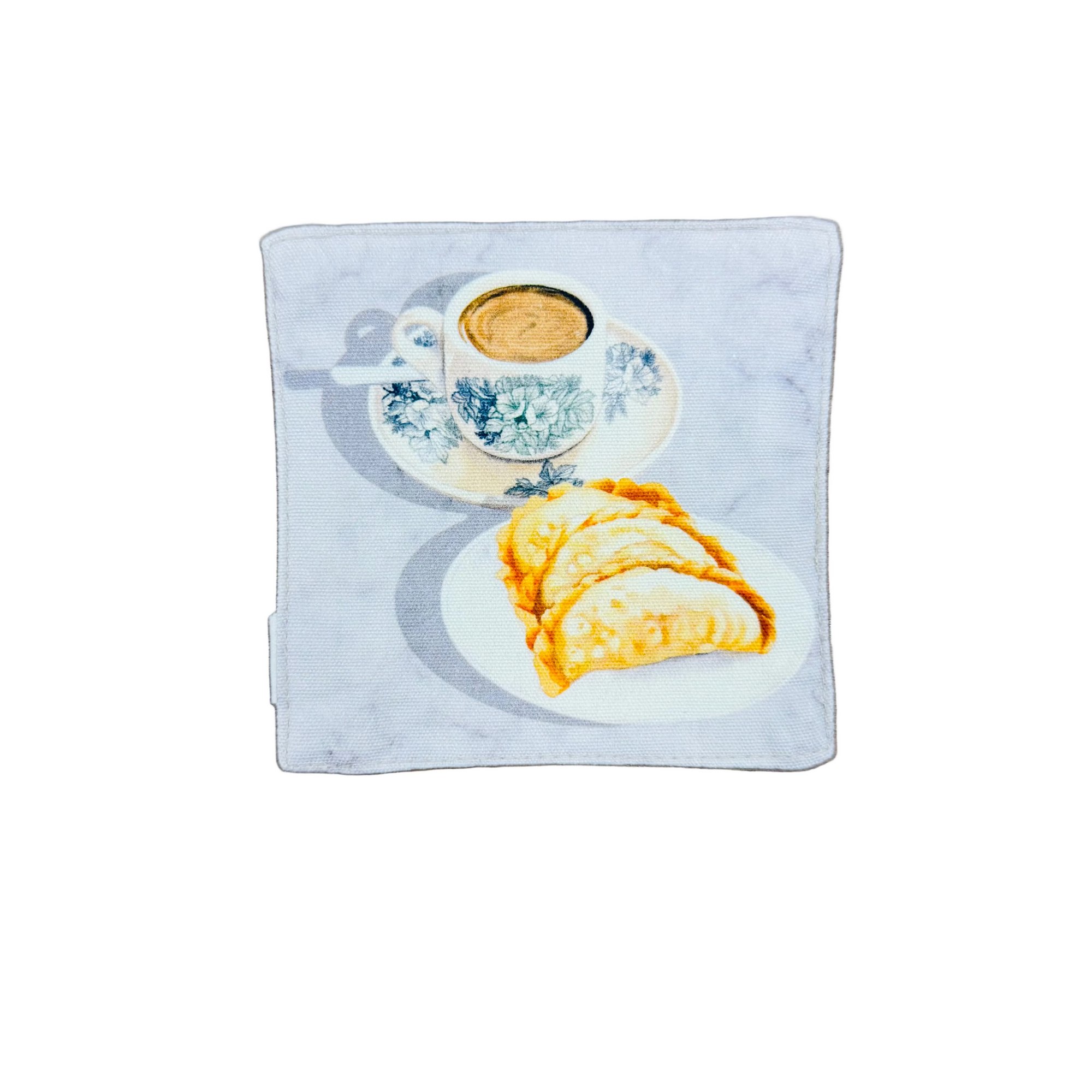 Kopi in an old school cup with a plate of curry puffs design on a fabric coaster.
