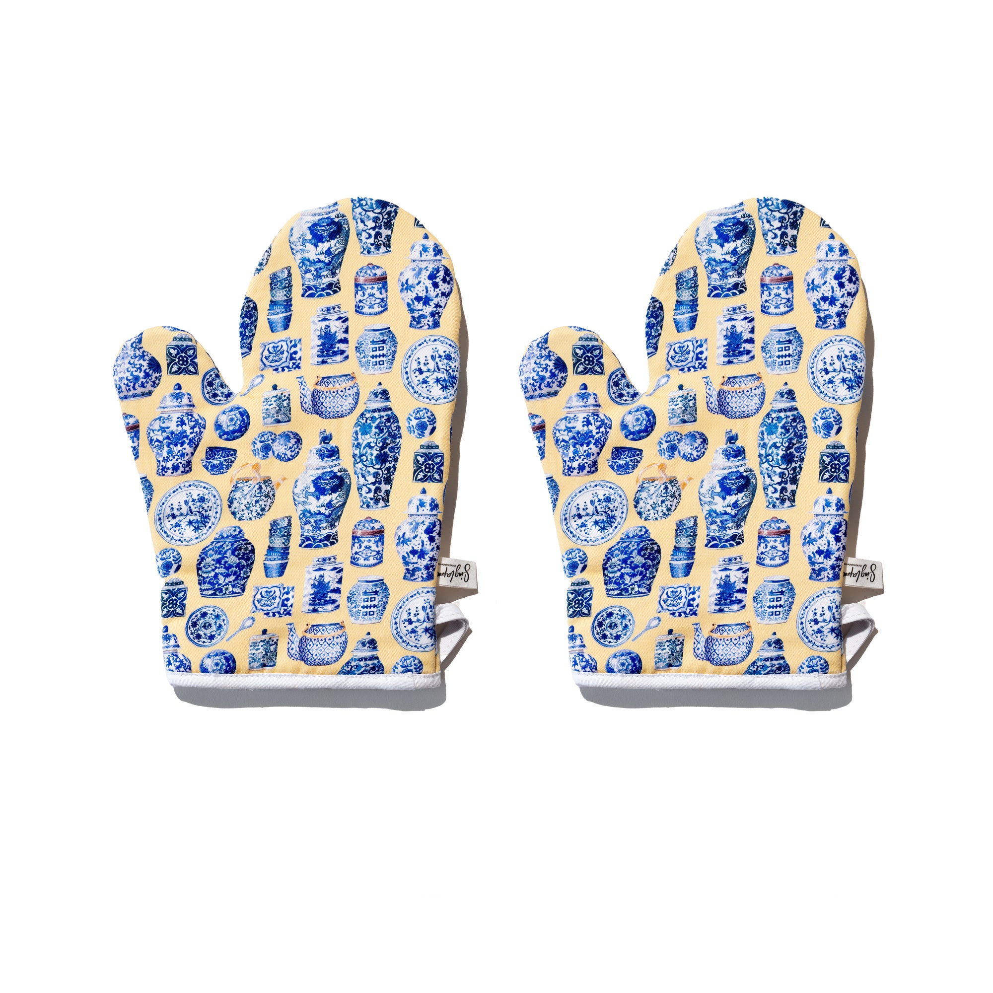 Singlapa yellow oven mitts with blue porcelain patterns on a white background.