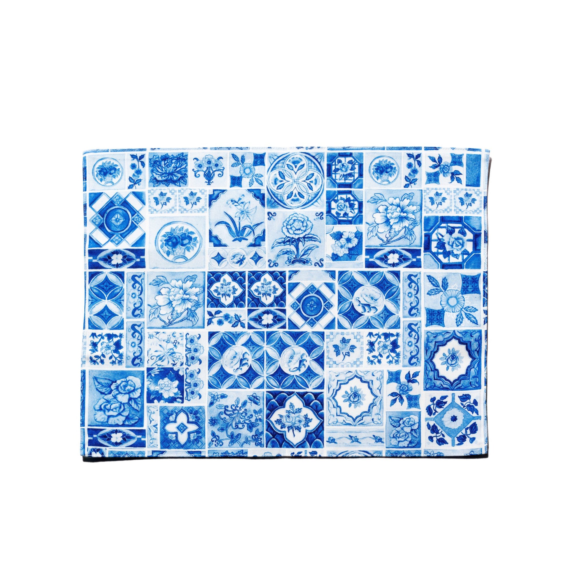 A double-sided placemat with blue and white outlined patterns, made of fabric.